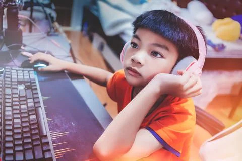 Asian kid is coding and scripting program on on his game streaming desktop co Stock Photos