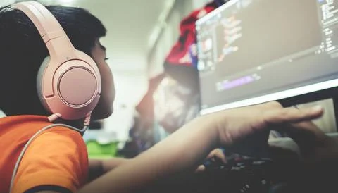 Asian kid is coding and scripting program on on his game streaming desktop co Stock Photos