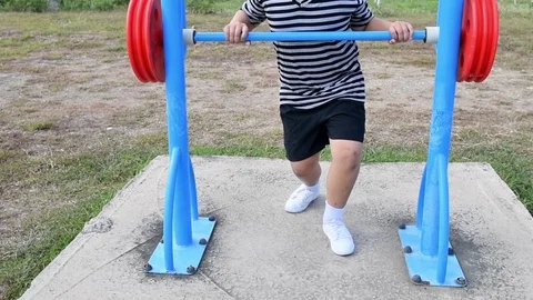 Asian kid exercise with Weight-lifting at outdoor fitness in public park, Stock Footage 113339308