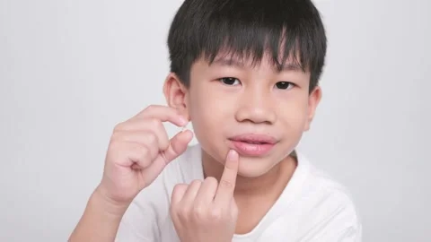 Asian kid holding the first fallen baby milk teeth while the second tooth loses. Stock-Footage 202259625