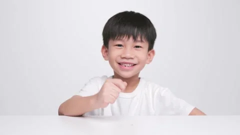 Asian kid holding the first fallen baby milk teeth. Stock Footage 220244691