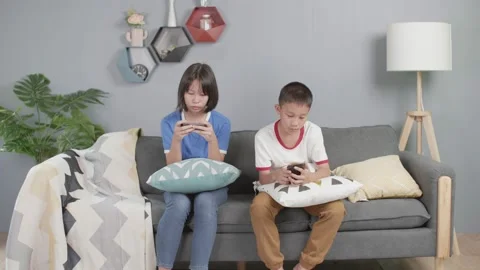 Asian kid sit on sofa and use mobile phone Stock-Footage 155735580