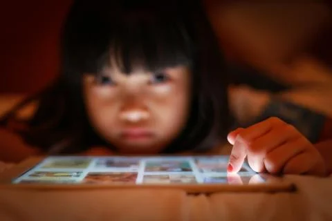 Asian kid using internet tablet screen. Stock Photos