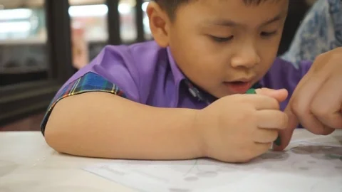 Asian kid writing paper at an restaurant 스톡 동영상 74606853