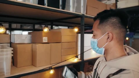 Asian korean man worker wearing protective face mask and check stock in Stock Footage 141014964