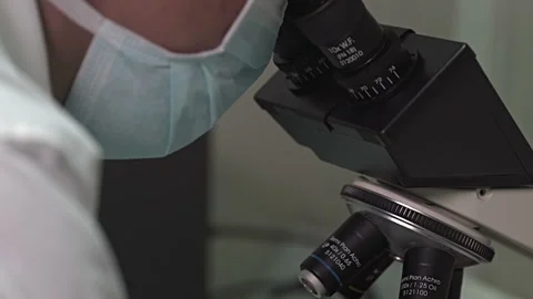 Asian Lab Tech with Microscope and a man looking through it Stock Footage 248795118