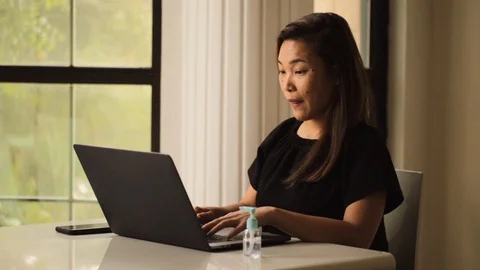 Asian lady working from home avoiding social distancing to fight coronavirus. Stock Footage 128086416