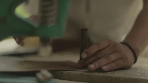 Asian leather smith, works with tools to make straps, slo-mo. Stock Footage 82329322