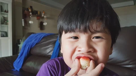 Asian little boy eats strawberries at home with smile face 스톡 동영상 89027800