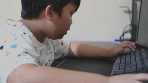 Asian little boy kid using computer and typing on keyboard. slow motion video 스톡 동영상 201232812