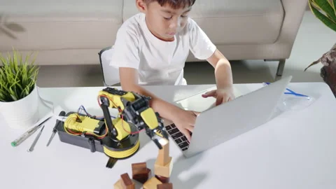 Asian little kid boy using laptop computer check on robotic arm machine in Stock Footage 192281026