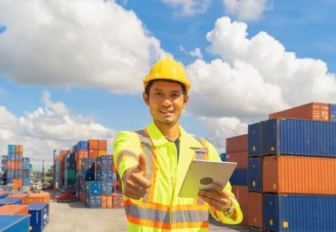 Asian logistic worker engineer man using a tablet, working in cargo container Stock Photos