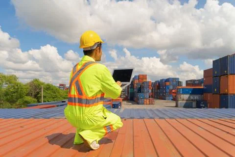 Asian logistic worker engineer man using a laptop computer, working in cargo  Stock Photos