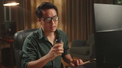 Asian Male Drinking Coffee While Works On His Personal Computer With Big 스톡 동영상 157782282