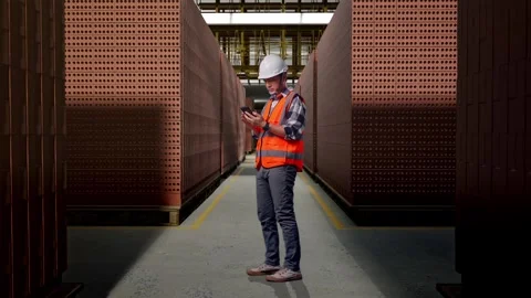 Asian Male Engineer Looking At The Tablet In His Hand With Brick In Stacks Stock Footage 303761413