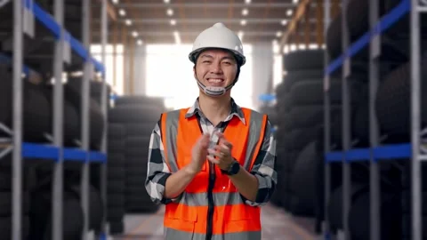 Asian Male Engineer Smiling And Clapping His Hands at Tire Warehouse Stock Footage 341787084