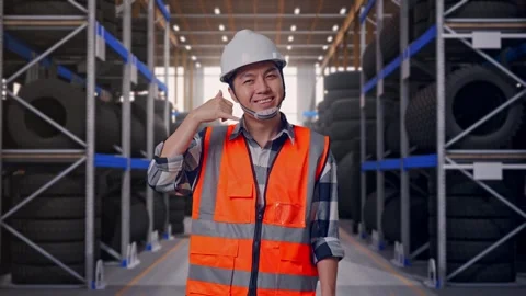 Asian Male Engineer Smiling To Camera And Making Call Me Gesture Tire Warehouse Stock Footage 341786336