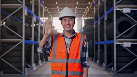Asian Male Engineer Smiling To Camera And Waving Hand Saying Bye Tire Warehouse Stock Footage 341786347