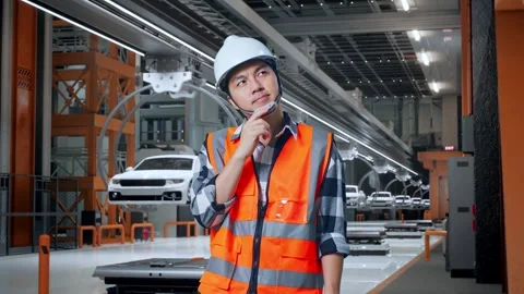 Asian Male Engineer Thinking About Something In EV Car Factory Stock Footage 279123714