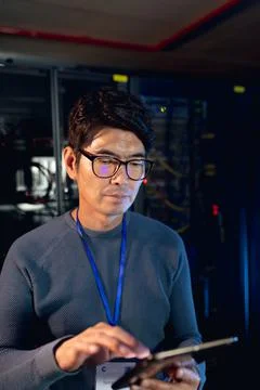 Asian male engineer using digital tablet in computer server room Foto stock