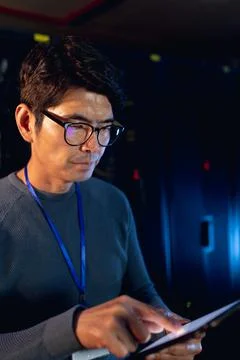 Asian male engineer using digital tablet in computer server room Foto stock