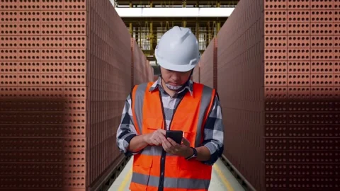 Asian Male Engineer Using Smartphone With Brick In Stacks Stock Footage 303759799
