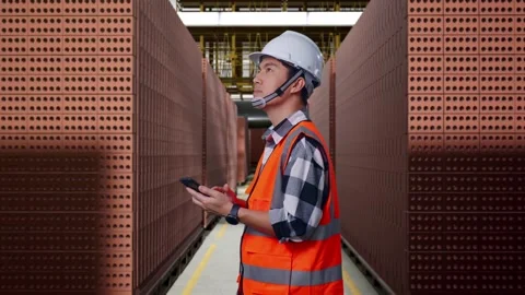 Asian Male Engineer Using Smartphone With Brick In Stacks Stock Footage 303760009