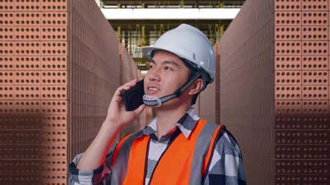 Asian Male Engineer Using Smartphone With Brick In Stacks Stock Footage 303760934