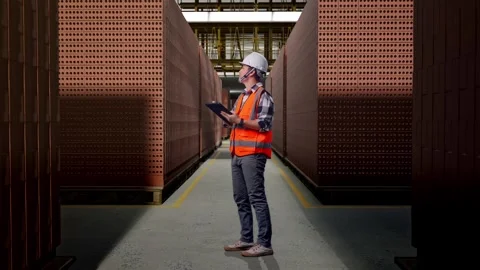 Asian Male Engineer Working On A Tablet With Brick In Stacks Stock Footage 303761375