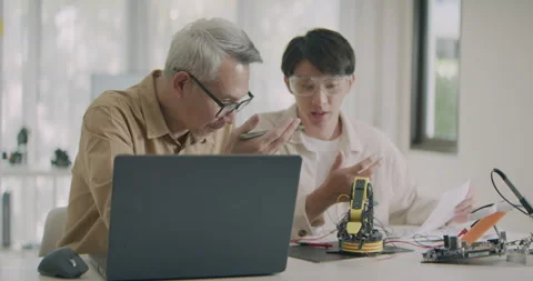 Asian Male Engineers Collaborating on Robotic Arm Project. Stock Footage 308159141
