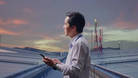 Asian Male Looks Up And To Keep On His Phone on Rooftop Solar Stock Footage 319829052