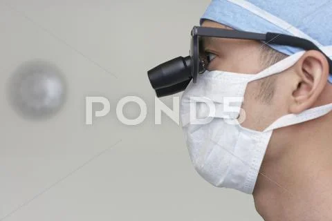 Asian Male Medical Professional Wearing Magnifying Glasses