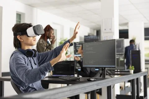 Asian male programmer interacting with 3d coding interface Stockfoto's