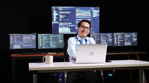 Asian Male Programmer Smiling To Camera And Cross Arm While Writing Code By Video stock 230169190