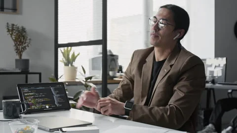 Asian Male Software Developer Coding on Laptop and Using Tablet in Office Stock Footage 336710655