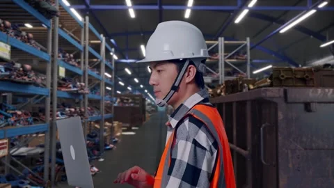 Asian Male Use Computer While Walking at Recycling Warehouse Stock Footage 318075807