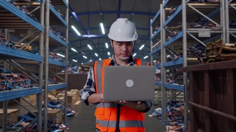 Asian Male Use Computer While Walking at Recycling Warehouse Stock Footage 318076263