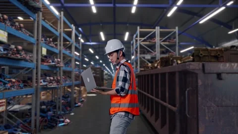 Asian Male Use Computer While Walking at Recycling Warehouse Stock Footage 318076574