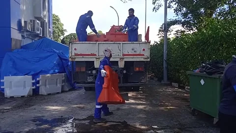 Asian Male Worker in Blue Loading Road Water Barriers onto Logistics Truck Stock Footage 309306939