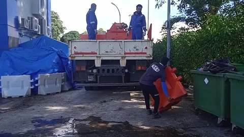 Asian Male Worker in Blue Loading Road Water Barriers onto Logistics Truck Stock Footage 309306940