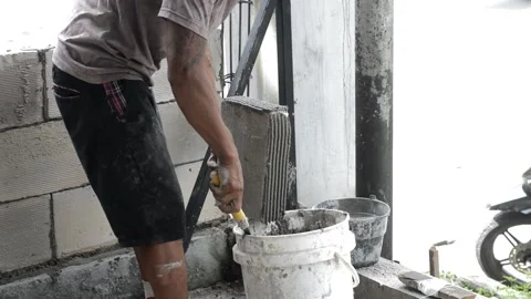 Asian male worker constructing a wall with light brick materials Stock Footage 245335750