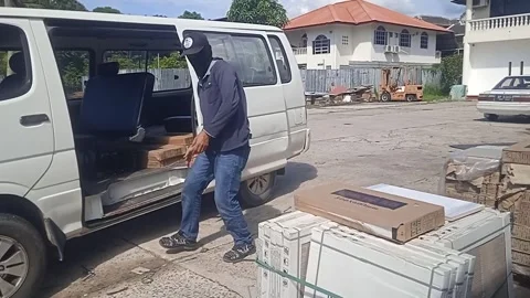 Asian Male Worker Loading Tiles Into White Car During Daytime Stock Footage 309306764