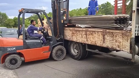 Asian Male Worker Loading Used Canopies onto Truck with Forklift During Daytime Stock Footage 309306917
