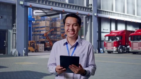 Asian Male Worker Smiling At The Camera, Outside Warehouse Stock Footage 295129239