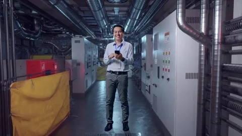Asian Male Worker Smiling While Use Smartphone In Engine Control Room Stock Footage 292373039