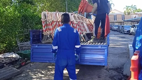 Asian Male Workers Load Plastic Road Barriers and Traffic Controls onto Trucks Stock Footage 309306841