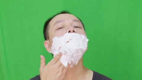 Asian man applying white shaving cream on his face ready to shave Stock Footage 315447633