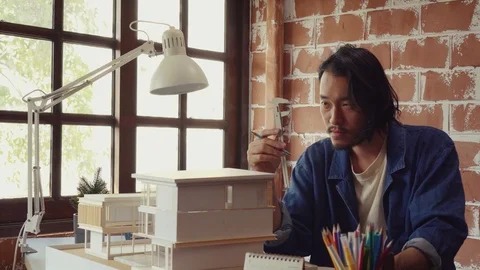 Asian man architecture/designer selecting wall color for model house/home Stock Footage 111679623
