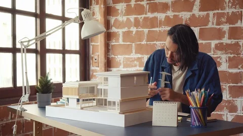 Asian man architecture/designer selecting wall color for model house/home Stock Footage 111679644