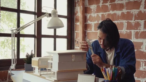 Asian man architecture/designer selecting wall color for model house/home Stock Footage 111679722